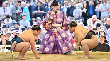 Pegulat sumo bersiap untuk bertanding dalam turnamen Honozumo di Kuil Yasukuni, Tokyo, Jepang, 15 April 2019. Turnamen seremonial ini diikuti oleh para jawara sumo. (TRIBALLEAU CHARLY/AFP)