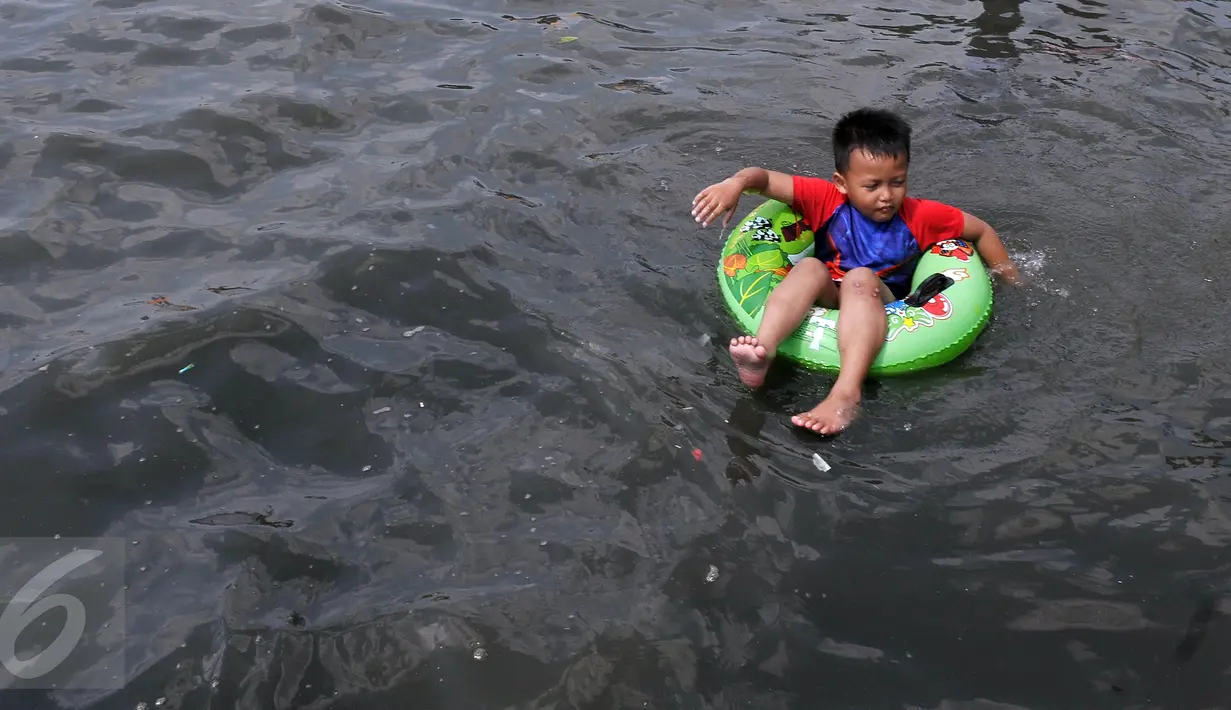 Seorang anak menggunakan pelampung saat berenang di pantai Ancol,  Jakarta, Kamis (7/7). Ancol tetap menjadi primadona tempat wisata bagi warga Jakarta dan sekitar untuk mengisi libur Lebaran. (Liputan6.com/Johan Tallo)