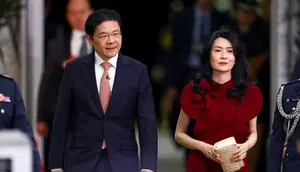 Perdana Menteri Singapura Lawrence Wong (kiri) tiba bersama istrinya Loo Tze Lui untuk upacara pelantikan dirinya dan kabinetnya di Istana di Singapura pada 23 Mei 2025. (Dok: Edgar Su / POOL / AFP)