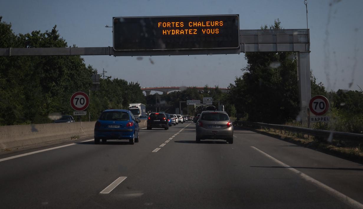 <p>Tanda jalan bertuliskan "Panas Ekstrem, minum air", memperingatkan pengendara tentang prakiraan gelombang panas saat suhu udara melebihi 42 derajat celsius di lingkar jalan di Nantes, Senin (18/7/2022). Peramal cuaca menempatkan 15 departemen di sebagian besar sisi barat Prancis ke status siaga tertinggi untuk suhu ekstrem. (Loic VENANCE / AFP)</p>