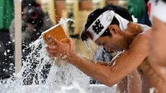 Penganut agama Shinto melakukan mandi air dingin di Kuil Kanda, Tokyo, Jepang (13/1). Mandi air dingin ini merupakan ritual yang digelar untuk menyucikan tubuh dan jiwa mereka. (AFP Photo/Toshifumi Kitamura)
