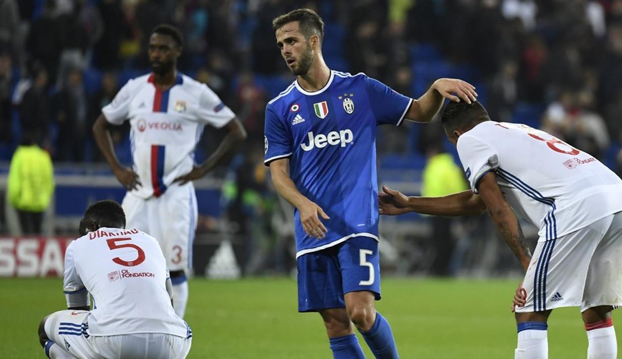Pemain Juventus, Miralem Pjanic, berusaha menghibur pemain Olympique Lyon seusai laga Grup H Liga Champions di Stade de Lyon, Prancis, Rabu (19/10/2016) dini hari WIB. (AFP/Philippe Desmazes)