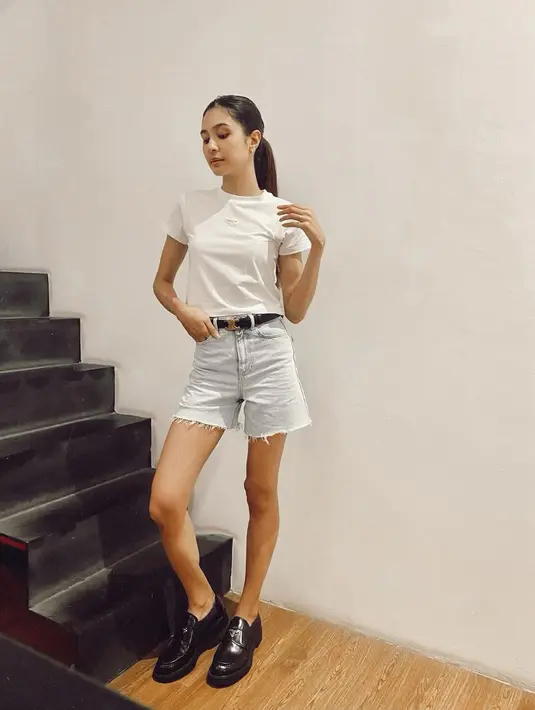 Mikha Tambayong tampil effortless chic dengan atasan kaus putih polos. Penampilannya ini dipadu dengan denim short dan loafers hitam. [Foto: Instagram/miktambayong]