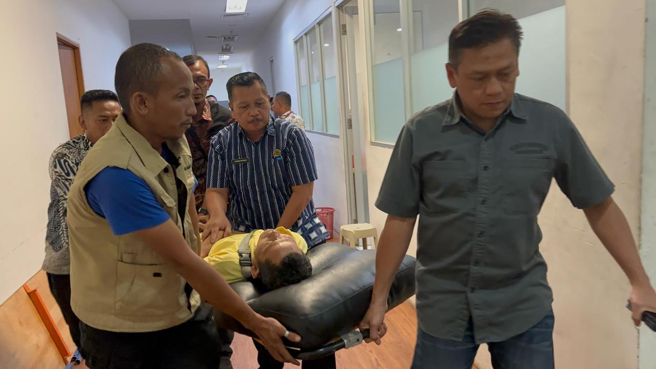 Seorang pria dievakuasi saat mengurus pemutihan pajak kendaraan milik anaknya, di Samsat Kelapa Dua Kabupaten Tangerang, Kamis (24/4/2025).