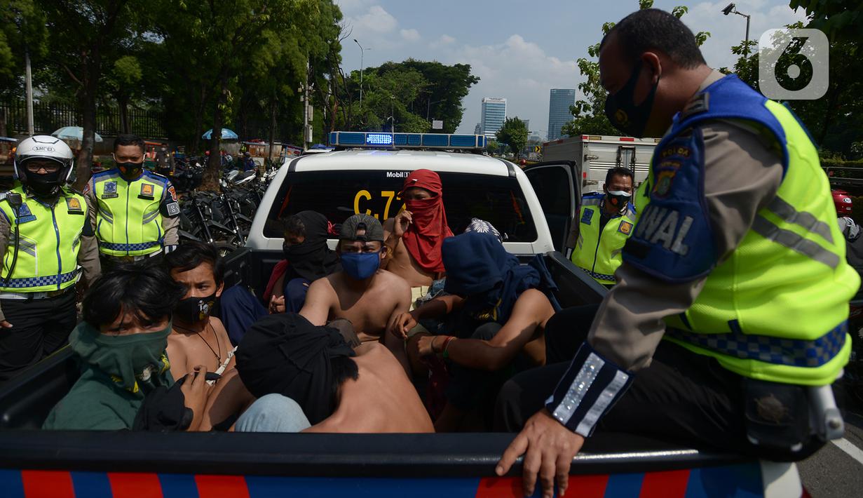 Sejumlah orang dibawa dengan kendaraan polisi setelah diamankan di Kawasan Senayan, Jakarta, Kamis (8/10/2020). Mereka diduga hendak melakukan unjuk rasa di depan gedung DPR. (merdeka.com/Imam Buhori)