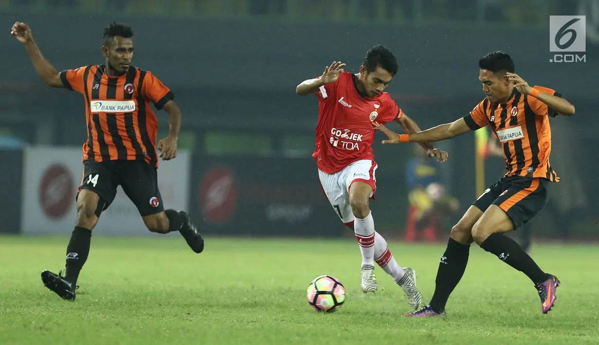 Gelandang Persija, Ambrizal Umanailo (tengah) mencoba lolos dari kawalan dua pemain Perserui dilanjutan Liga 1 Indonesia di Stadion Patriot Candrabhaga, Bekasi, Selasa (13/6). Persija menang telak 3-0 atas perserui. (Liputan6.com/Helmi Fithriansyah)