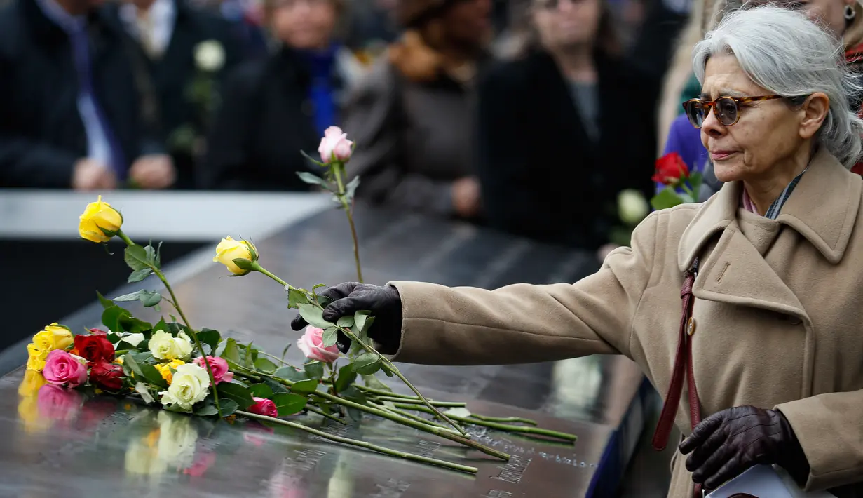 Orang-orang menaruh bunga mawar di atas nama korban pengeboman World Trade Center 1993 pada upacara peringatan “Tragedi 9/11” di New York, Rabu (26/2/2020). 27 tahun lalu teroris meledakkan bom di sebuah garasi parkir World Trade Center (WTC) yang menewaskan enam korban. (AP/John Minchillo)