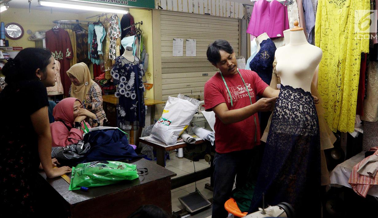 Seorang penjahit mengukur baju di Pasar Mayestik, Jakarta Selatan, Senin (11/6). Masyarakat mulai membeli dan membuat baju pilihan mereka jelang Lebaran. (Liputan6.com/JohanTallo)