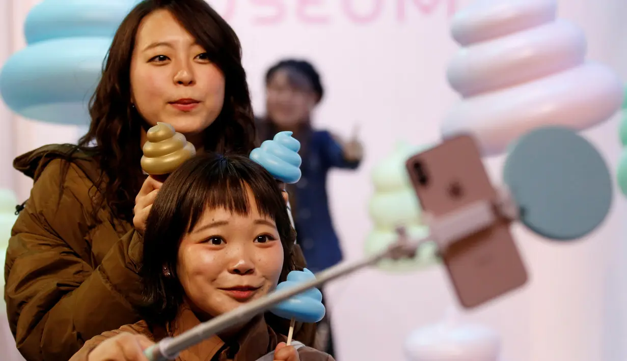 Pengunjung berswafoto dengan miniatur kotoran saat mengunjungi Museum Unko di Yokohama, Jepang pada Rabu (17/4). Kali ini, Negeri Sakura itu baru saja membuka sebuah museum pop-up bertema unik dan tak biasa, yaitu tinja atau kotoran (poop). (REUTERS/Kim Kyung-hoon)
