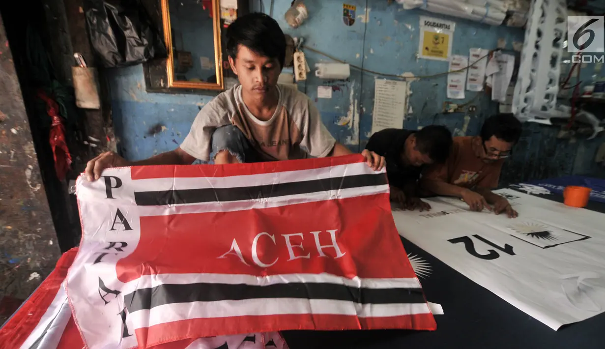 Pekerja menunjukkan bendera salah satu partai politik yang telah selesai dibuat di Percetakan Andalas Jaya, Jakarta, Rabu (2/1). Omzet dari percetakan sablon bendera dan spanduk partai ini mencapai Rp 60 juta per minggu. (Merdeka.com/Iqbal Nugroho)