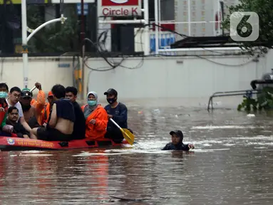 Petugas menggunakan perahu karet mengevakuasi beberapa warga yang terjebak banjir di kawasan Jalan Kemang Raya, Jakarta, Sabtu (20/2/2021). Hujan yang mengguyur Jakarta sejak Jumat (19/2) membuat sejumlah titik di Jakarta terendam banjir. (Liputan6.com/Helmi Fithriansyah)