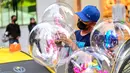 Seorang pedagang yang mengenakan masker menjajakan balon di sebuah jalan di Kuala Lumpur, Malaysia, pada 10 Desember 2020. Menurut Kementerian Kesehatan pada Kamis (10/12), total kasus COVID-19 nasional di Malaysia mencapai 78.499. (Xinhua/Chong Voon Chung)