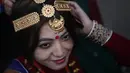 Seorang wanita memakai perhiasan jelang parade "Tamu Losar", Kathmandu, Nepal, Jumat (30/12). Parade tersebut digelar untuk menyambut pergantian tahun. (AP Photo / Niranjan Shrestha)