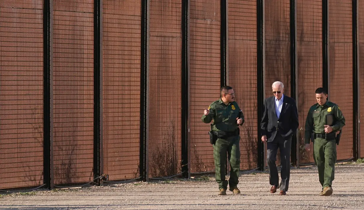 Presiden Amerika Serikat Joe Biden berjalan dengan agen Patroli Perbatasan AS di sepanjang perbatasan AS-Meksiko di El Paso Texas, AS, 8 Januari 2023. Kunjungan ini untuk melihat langsung keamanan perbatasan dengan perlintasan imigran yang terus meningkat. (AP Photo/Andrew Harnik)