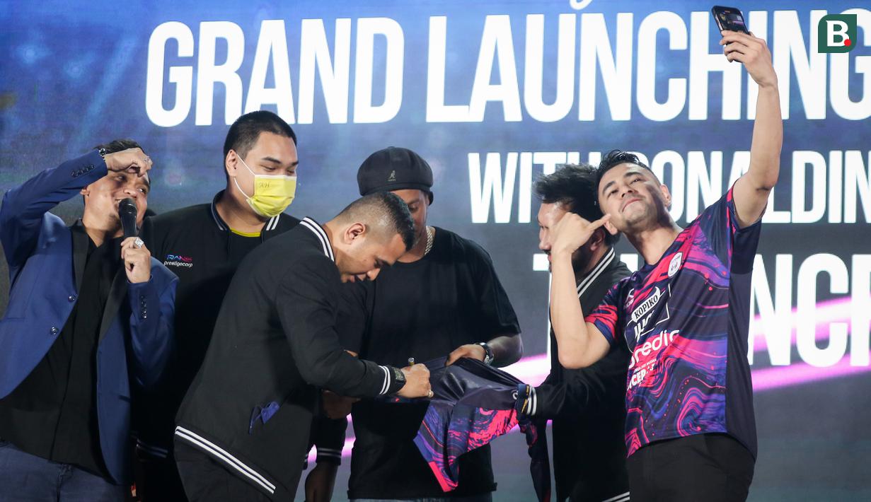 <p>Raffi Ahmad (kanan) berswafoto bersama Ronaldinho (tengah) yang sedang menandatangani jersey Rans Nusantara FC saat Grand Launching Jersey Rans Nusantara FC bersama Ronaldinho di Menara Mandiri Level 9, Sudirman, Jakarta, Jumat (24/06/2022). (Bola.com/Bagaskara Lazuardi)</p>