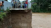 banjir besar akibat hujan deras dan luapan sungai Cimadur, merendam rumah warga dan memutuskan jembatan di Kecamatan Bayah. (Liputan6.com/Yandhi)