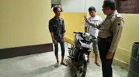 Dua pemuda berboncengan tanpa helm dan STNK datangi kantor polisi demi mengurus SKCK. (Liputan6.com/Gun ES)