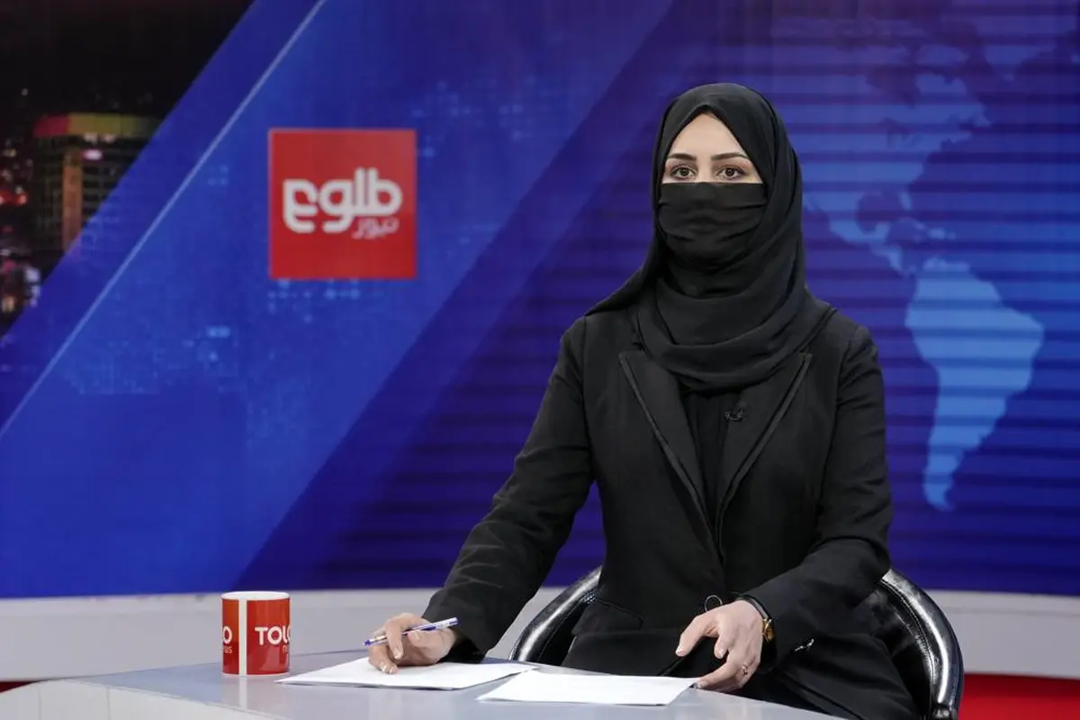 Khatereh Ahmadi, seorang presenter TOLO News di Kabul, Afghanistan hari Minggu (22/5/2022) mengudara dengan wajah tertutup. (AP)