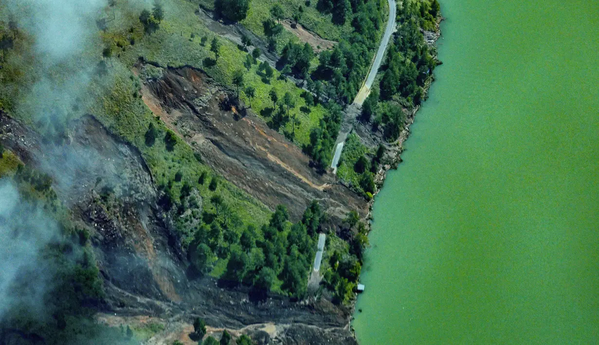 Sebuah jalan terlihat rusak akibat longsor akibat banjir bandang di Kabupaten Bener Meriah, Provinsi Aceh, pada Kamis 4 Desember 2025. (CHAIDEER MAHYUDDIN/AFP)
