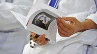 Seorang biarawati membaca sebuah flyer bergambar Bunda Teresa di Kalkuta, India (11/9/2016). (AFP/Robert Atanasovski)