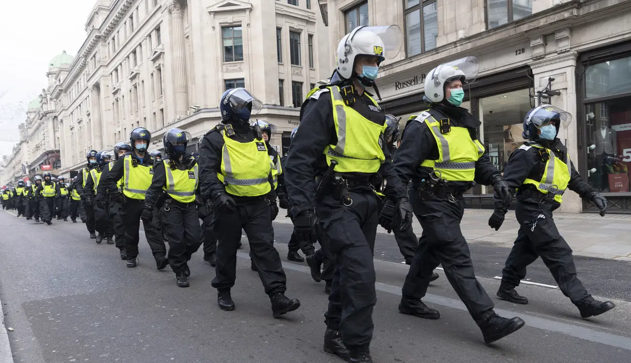 Para petugas polisi terlihat di sebuah jalan dalam aksi protes anti-lockdown di London, Inggris, 28 November 2020. Lebih dari 60 orang ditangkap saat bentrokan antara sejumlah demonstran anti-lockdown dan polisi di pusat kota London pada Sabtu (28/11). (Xinhua/Ray Tang)