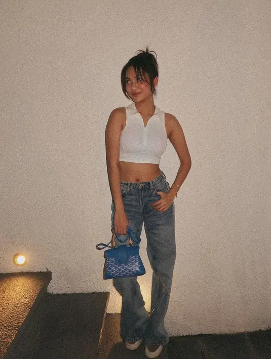 Azizah Salsha tampil chic dengan cropped top berkerah tanpa lengan berwarna putih dan celana jeans panjang. [Foto: Instagram/azizahsalsha_]