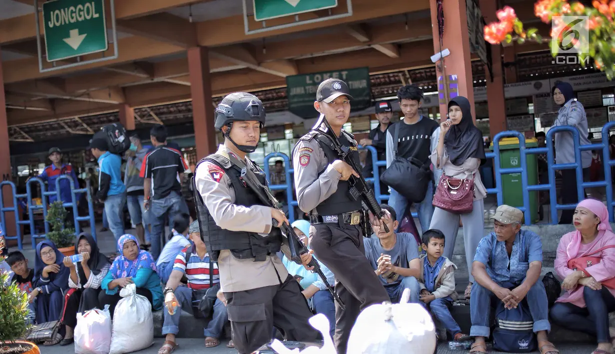 Pasukan Brimob Polda Metro Jaya bersenjata lengkap patroli di Terminal Kampung Rambutan, Jakarta, Selasa (19/6). Penjagaan dilakukan untuk memberi rasa aman kepada pemudik pada arus balik Lebaran 2018. (Liputan6.com/Faizal Fanani)