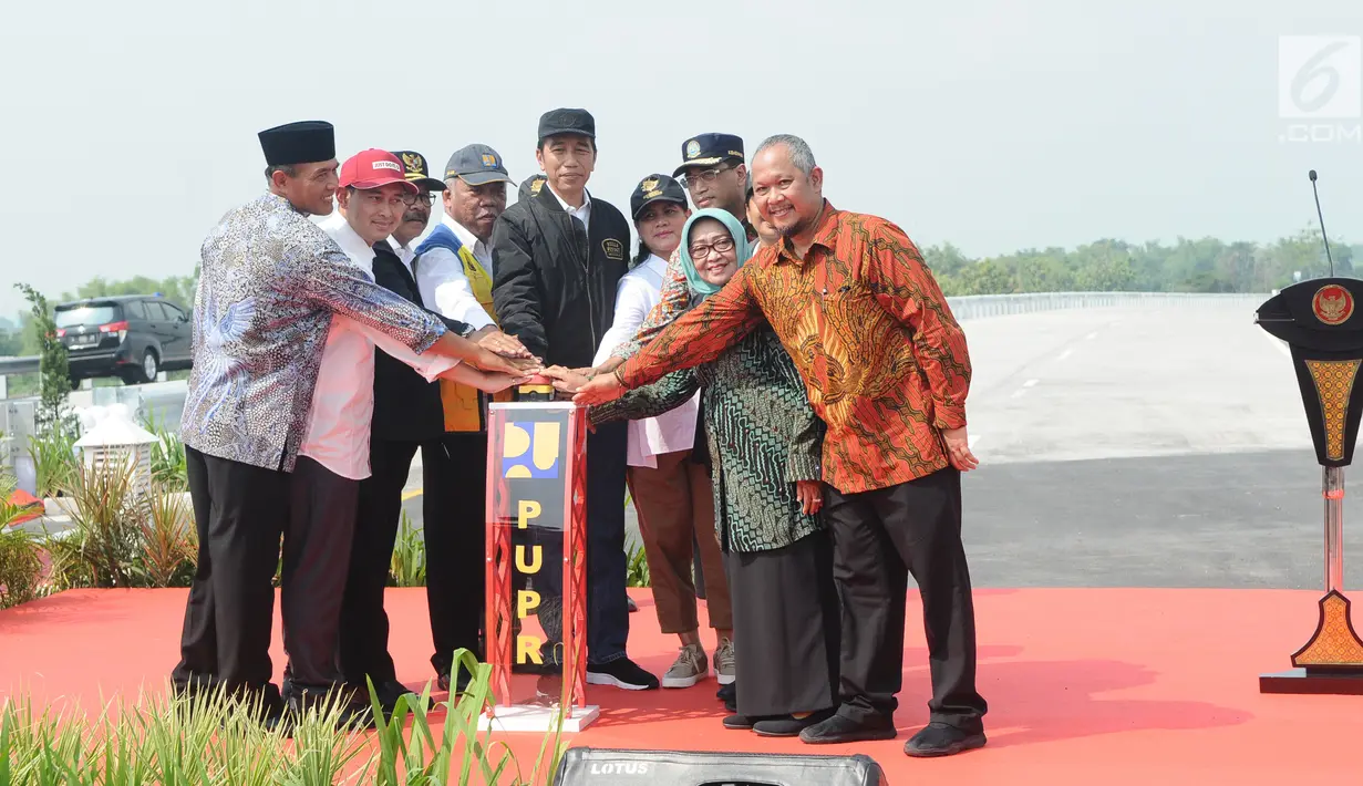 Presiden Joko Widodo (Jokowi) didampingi Ibu Negara Iriana Joko Widodo menekan tombol saat meresmikan empat ruas tol di Jawa Timur, Kamis (20/12). Peresmian ini menandakan Jakarta dengan Surabaya tersambung via Tol Trans-Jawa. (Liputan6.com/Angga Yuniar)