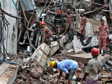 Petugas pemadam kebakaran penyelamat Bangladesh berdiri di puing-puing bekas ledakan di sebuah pabrik garmen di Dhaka, Bangladesh (4/7). Pabrik garmen di Bangladesh meledak hingga menewaskan 10 orang dan melukai puluhan lainnya. (AP Photo / AM Ahad)
