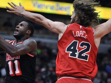 Pemain Miami Heat, Dion Waiters (tengah) melakukan tembakan saat diadang pemain Chicago Bulls, Robin Lopez (42) dan Justin Holiday (7) pada laga NBA basketball game di United Center, Chicago, (26/11/2017). Miami Heat menang 100-93.  (AP/Paul Beaty)