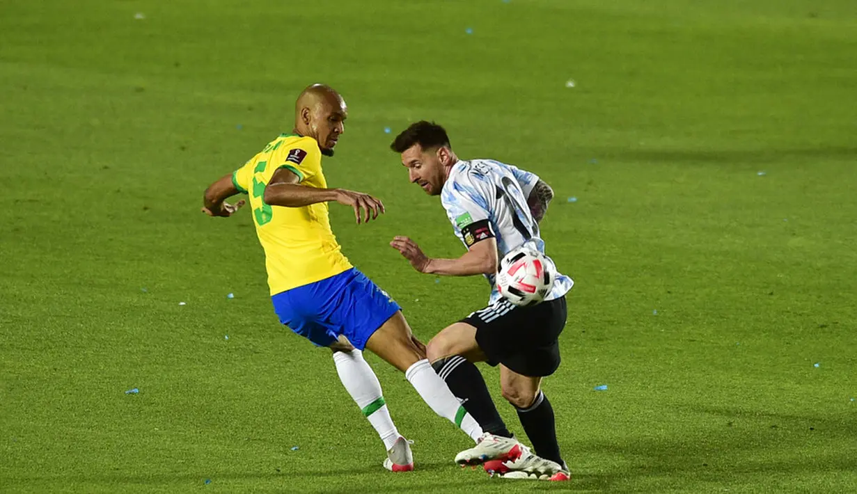 Pemain Argentina Lionel Messi (kanan) berebut bola dengan pemain Brasil Edenilson pada pertandingan sepak bola kualifikasi Piala Dunia 2022 di Stadion Bicentenario, San Juan, Argentina, 16 November 2021. Pertandingan berakhir dengan skor 0-0. (AP Photo/Gustavo Garello)