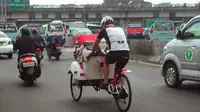 Bukan tanpa alasan seorang bule mengayuh becak di tengah jalanan Jakarta yang terik