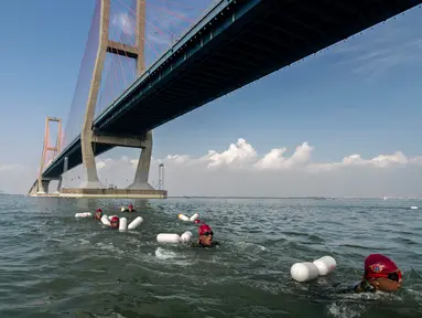 Prajurit Korps Marinir TNI AL berenang melintas selat Madura dari Surabaya sepanjang 5,4 km, Kamis (28/4). Renang yang mengambil start di Jembatan Suramadu dan finish di Bangkalan Madura ini untuk memperingati HUT Pasmar 1 ke-15. (Juni KRISWANTO/AFP)