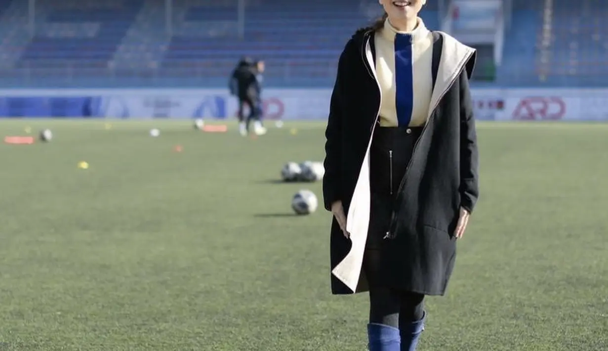 Meski di tengah lapangan, ia tetap tampil fashionable dengan coat hitam dan dalaman turtleneck, dipadukan dengan skirt hitam dan knee boots heels birunya. @panhlamaam.