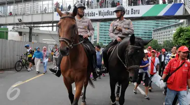 Petugas kepolisian menunggang kuda saat melakukan pengamanan di Car free day, Jakarta, Minggu (21/02). Polisi berkuda ini menjadi perhatian masyarakat yang sedang menikmati Car Free Day (CFD). (Liputan6.com/Helmi Afandi)