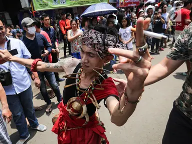 Tatung pria melakukan atraksi dalam Festival Cap Go Meh 2570 di Seasons City, Jakarta,  Minggu (24/3). Sekitar 100 tatung pria dan wanita hadir menampilkan atraksi ekstrem menggunakan benda tajam. (Liputan6.com/Fery Pradolo)