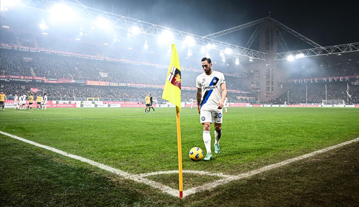 Pemain Inter Milan, Hakan Calhanoglu bersiap melakukan tendangan sepak pojok dengan latar stadion yang dipenuhi asap saat laga lanjutan Liga Italia 2023/2024 melawan Genoa di Stadion Luigi Ferraris, Genoa, Italia, Sabtu (30/12/2023) dini hari WIB. (AFP/Piero Cruciatti)