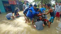 Warga Gotong-Royong Evakuasi Kendaraan Menggunakan Rakit. (Selasa, 08/12/2020). (Yandhi Deslatama/Liputan6.com)