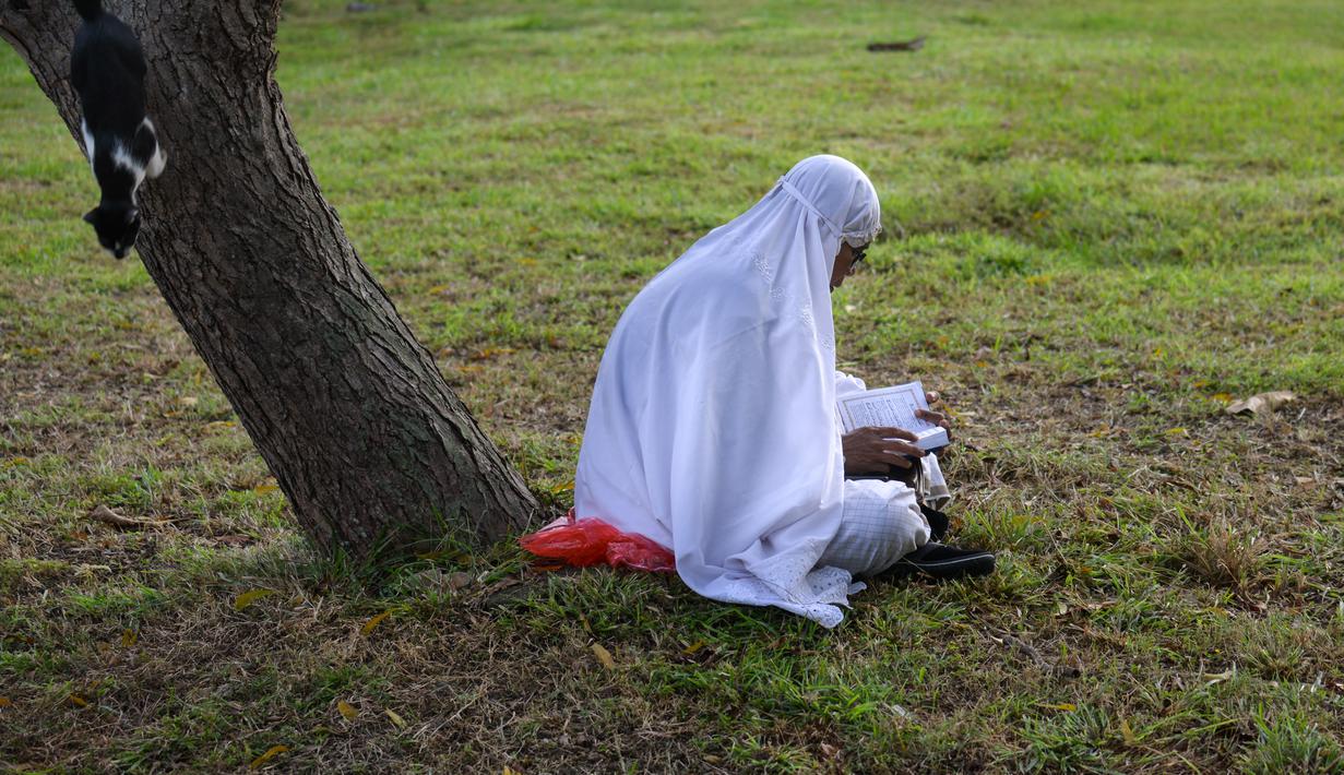 Seorang perempuan berdoa saat memperingati 18 tahun musibah gempa dan tsunami di kuburan massal Siron, Aceh, Senin (26/12/2022). Tsunami Aceh pada 2004 merenggut nyawa lebih dari 170.000 orang di Indonesia saja. (AFP/Chaideer Mahyuddin)
