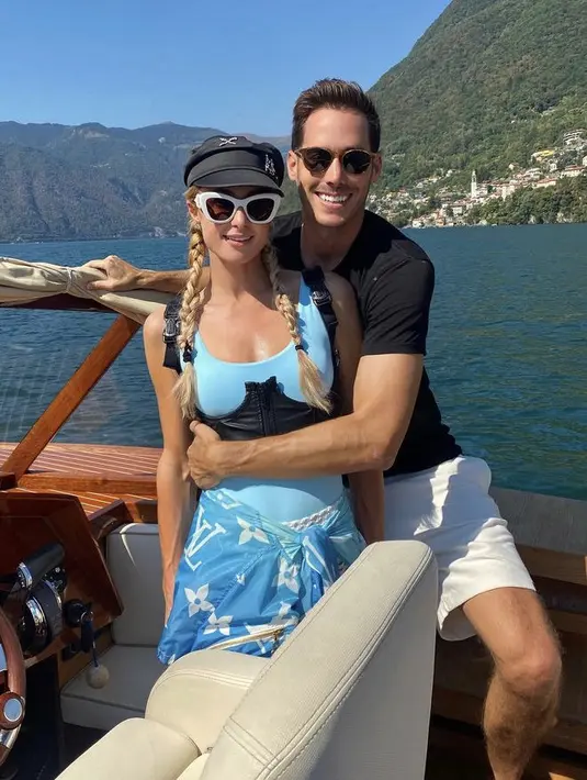 Ketika berlibur, Paris tetap tampil gorgeous dengan bikini biru dipadukan korset hitam yang serasi dengan topinya. Jaket Louis Vuitton pun diikat di pinggangnya.(@parishilton)