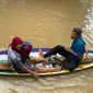 Warga di Rokan Hulu mengungsi pakai perahu karena rumahnya terendam banjir. (Liputan6.com/Istimewa)