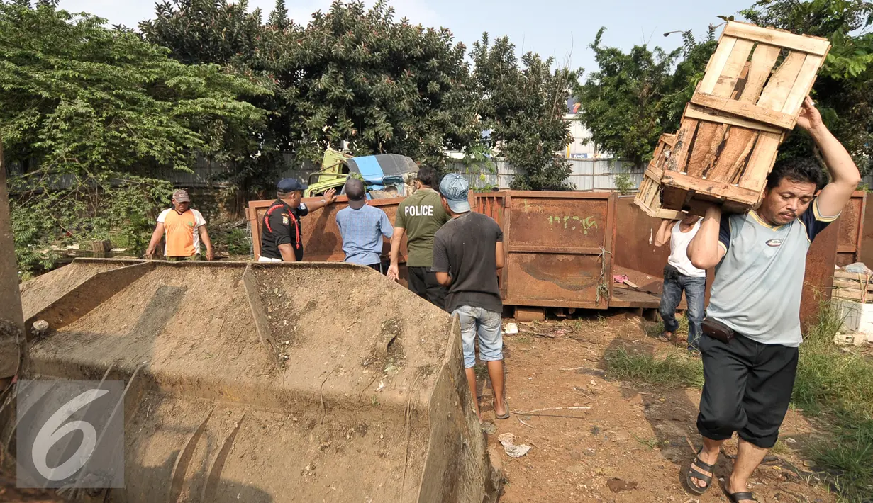 Pekerja mengangkat peti di area yang akan dibangun pusat perkulakan di Pasar Kramat Jati, Jakarta, Jumat (2/9). Pembangunan pusat perkulakan ini untuk menekan harga sembako di Ibukota. (Liputan6.com/Yoppy Renato)