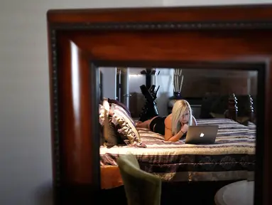 Pekerja seks komersil, Paris Envy bermain laptop di rumah bordil Love Ranch di Crystal, Nevada, AS, (27/4). Koalisi kelompok agama dan aktivis perdagangan anti-seks meluncurkan referendum melarang keberadaan rumah bordil di Nevada. (AP Photo/John Locher)