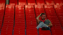 Fans Liverpool duduk sambil memegang kepalanya usai pertandingan melawan Wolverhampton Wanderers pada lanjutan Liga Inggris di stadion Anfield (12/5/2019). Meskipun menang 2-0, Liverpool gagal meraih juara Liga Inggris karena Manchester City mengalahkan Brighton 4-1. (AP Photo/Dave Thompson)