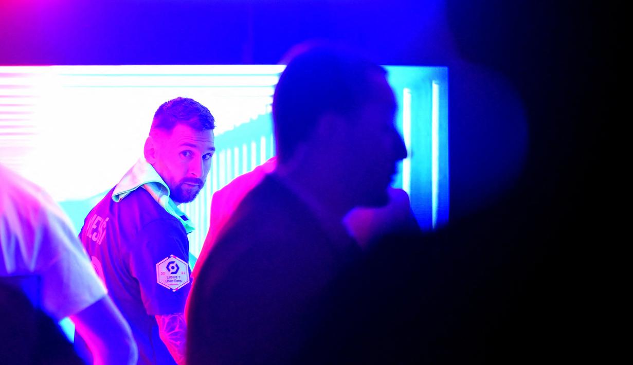 Pemain Paris Saint-Germain, Lionel Messi, memilih memasuki ruang ganti pemain dan meninggalkan rekan satu timnya yang sedang merayakan pesta juara Liga Prancis 2022/2023 di Parc des Princes Stadium, Minggu (4/6/2023) dini hari WIB. (AFP/Franck Fife)