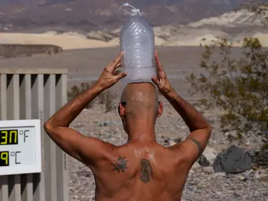 Steve Krofchik mendinginkan kepalanya dengan botol berisi es batu di Taman Nasional Death Valley, California, Amerika Serikat, Senin (17/8/2020). Temperatur udara tertinggi di Dunia -- 54,4 derajat Celcius -- tercatat di Taman Nasional Death Valley pada Minggu 16 Agustus. (AP Photo/John Locher)