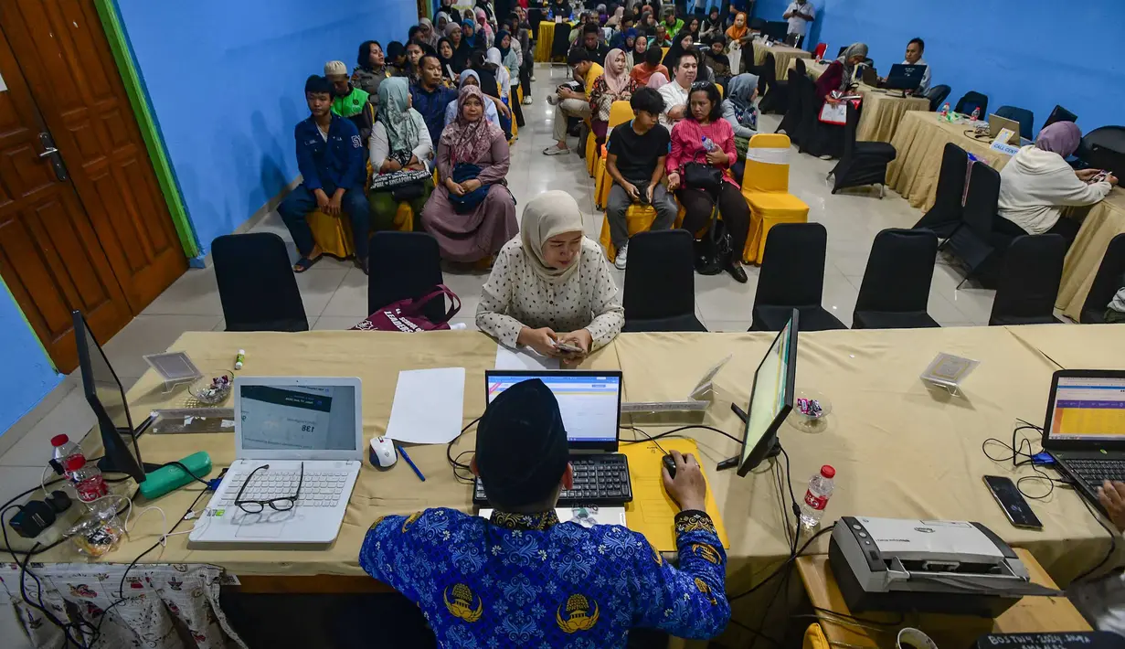 Petugas melayani orang tua calon siswa yang mencari informasi mengenai Sistem Penerimaan Murid Baru (SPMB) Tahun Ajaran 2026/2027 di Posko Pelayanan SPMB Suku Dinas Pendidikan Wilayah III yang berada di SMAN 70 Jakarta, Rabu (17/6/2026). (merdeka.com/Arie Basuki)