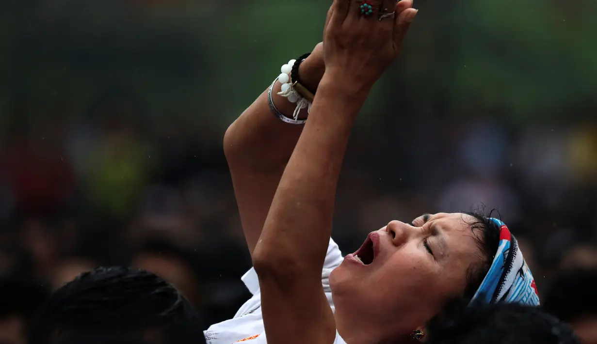 Seorang wanita kesurupan meniru binatang buas selama Festival Tato Suci di kuil Wat Bang Phra, Nakhon Pathom, Thailand (16/3). Acara tahunan ini digelar untuk mengisi ulang kekuatan tato suci di tubuh mereka. (Reuters/Athit Perawongmetha)