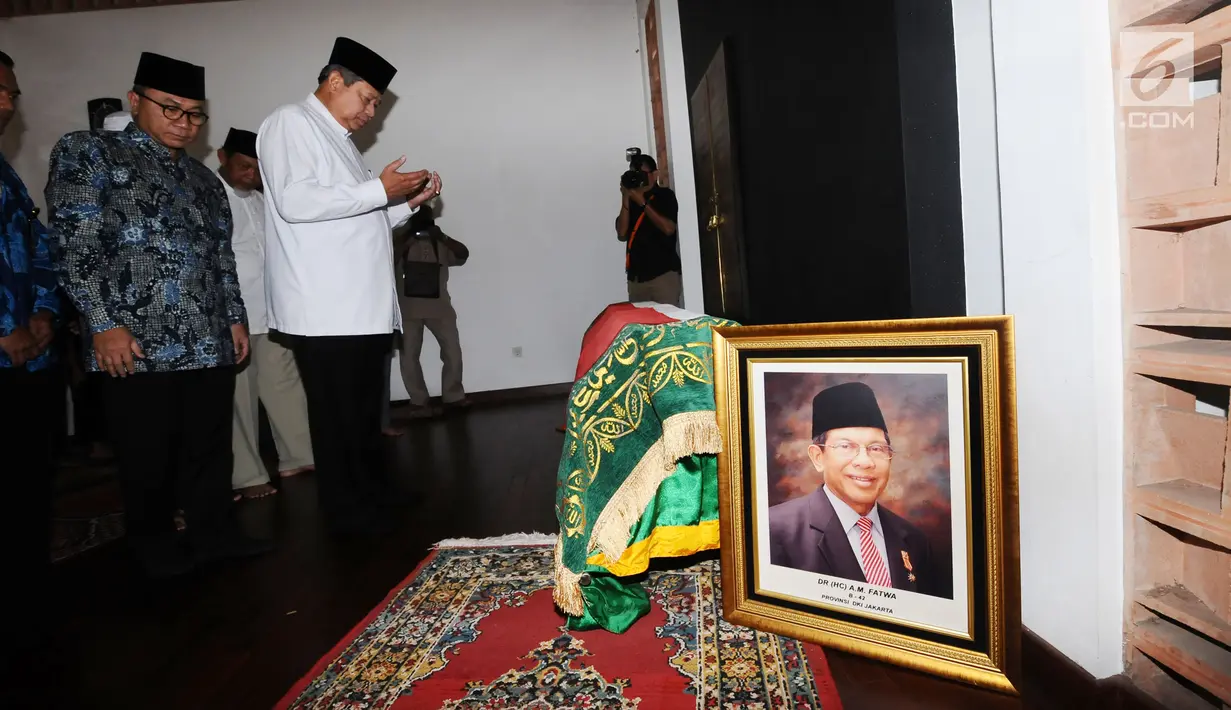 Presiden ke-6 RI, Susilo Bambang Yudhoyono berdoa di sisi jenazah AM Fatwa saat melayat di rumah duka di kawasan Pejaten, Jakarta, Kamis (14/12). AM Fatwa wafat pada usia 78 tahun di Jakarta. (Liputan6.com/Helmi Fithriansyah)