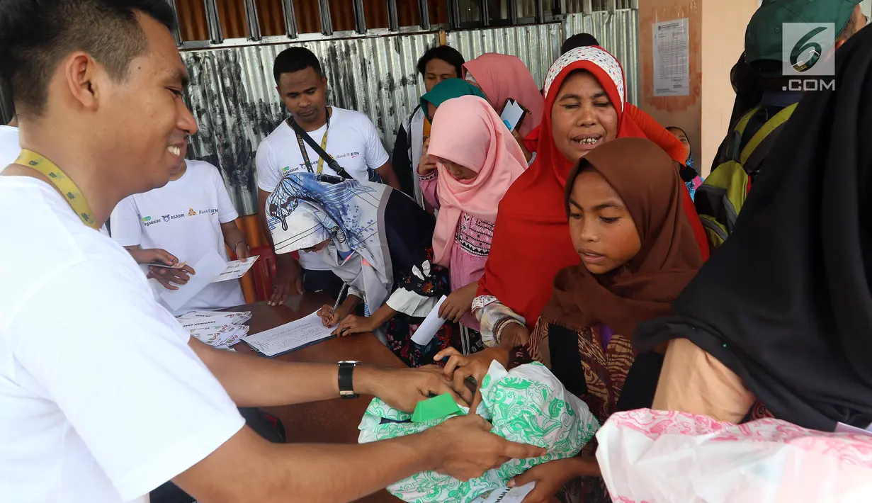 Anak-anak mengambil bantuan berupa perlengkapan sekolah saat Natal bersama dan bantuan CSR Sinergi BUMN di Kota Waingapu, Sumba Timur, Sabtu (15/12). BUMN kembali bersinergi meningkatkan kehidupan sosial. (Liputan6.com/JohanTallo)